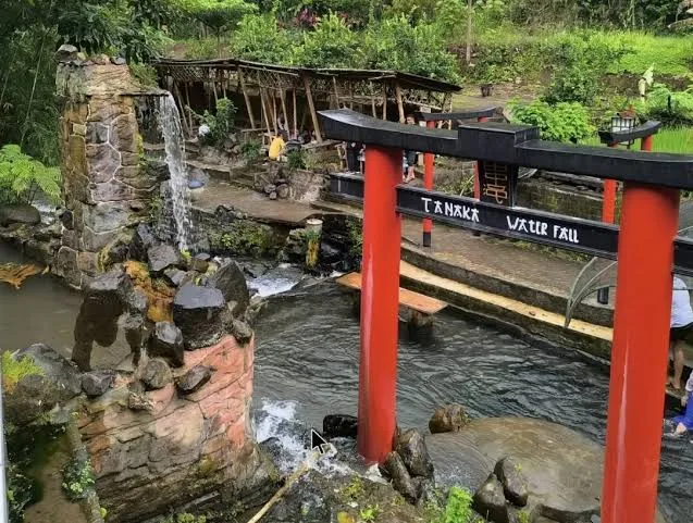 Gerbang Torii merah ikonik Umbulan Tanaka yang mencolok dengan arsitektur tradisional Jepang, dikelilingi taman asri di Malang.